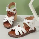 Une paire de sandales à talons mi-hauts avec des brides creuses tissées rondes classiques pour les petites filles