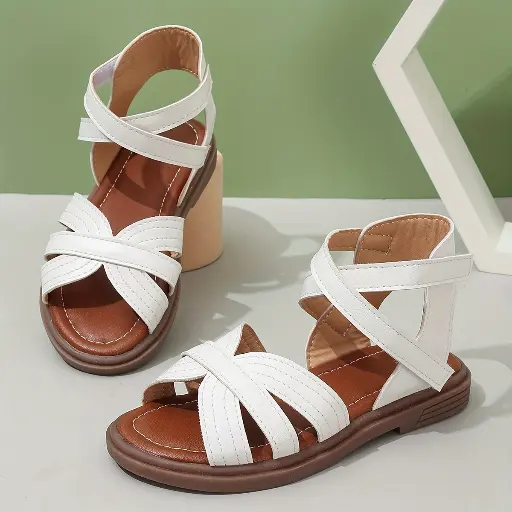 Une paire de sandales à talons mi-hauts avec des brides creuses tissées rondes classiques pour les petites filles
